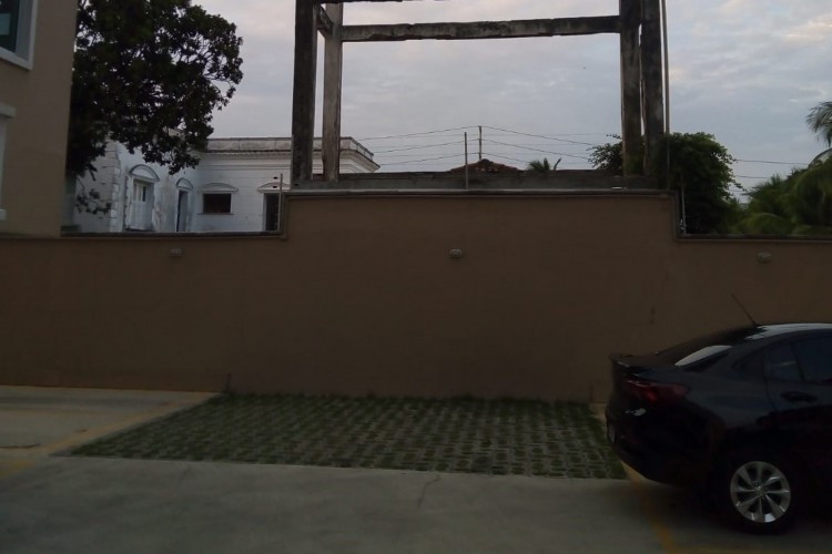 A caixa d'água fica ao lado de uma das paredes que cerca o imóvel