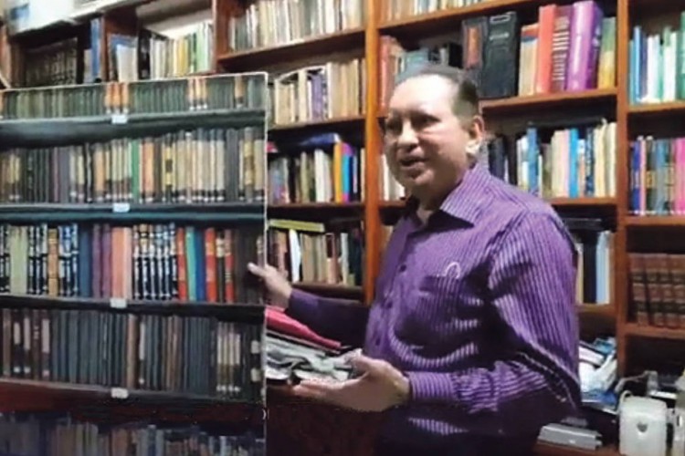 Desembargador Yedo Simões mostra biblioteca real após painel falso despencar durante sessão. A cena viralizou nas redes sociais