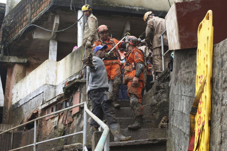 Bombeiros, moradores e voluntários trabalham no local do deslizamento no Morro da Oficina, após a chuva que castigou Petrópolis, na região serrana fluminense