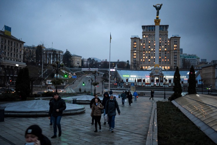 Pessoas caminham no centro de Kiev nesta quinta-feira, 24, após anúncio de invasão pela Rússia(Foto: Daniel LEAL / AFP)