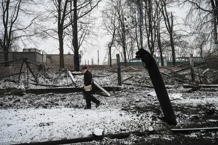 Homem passa por prédio destruído em Kiev