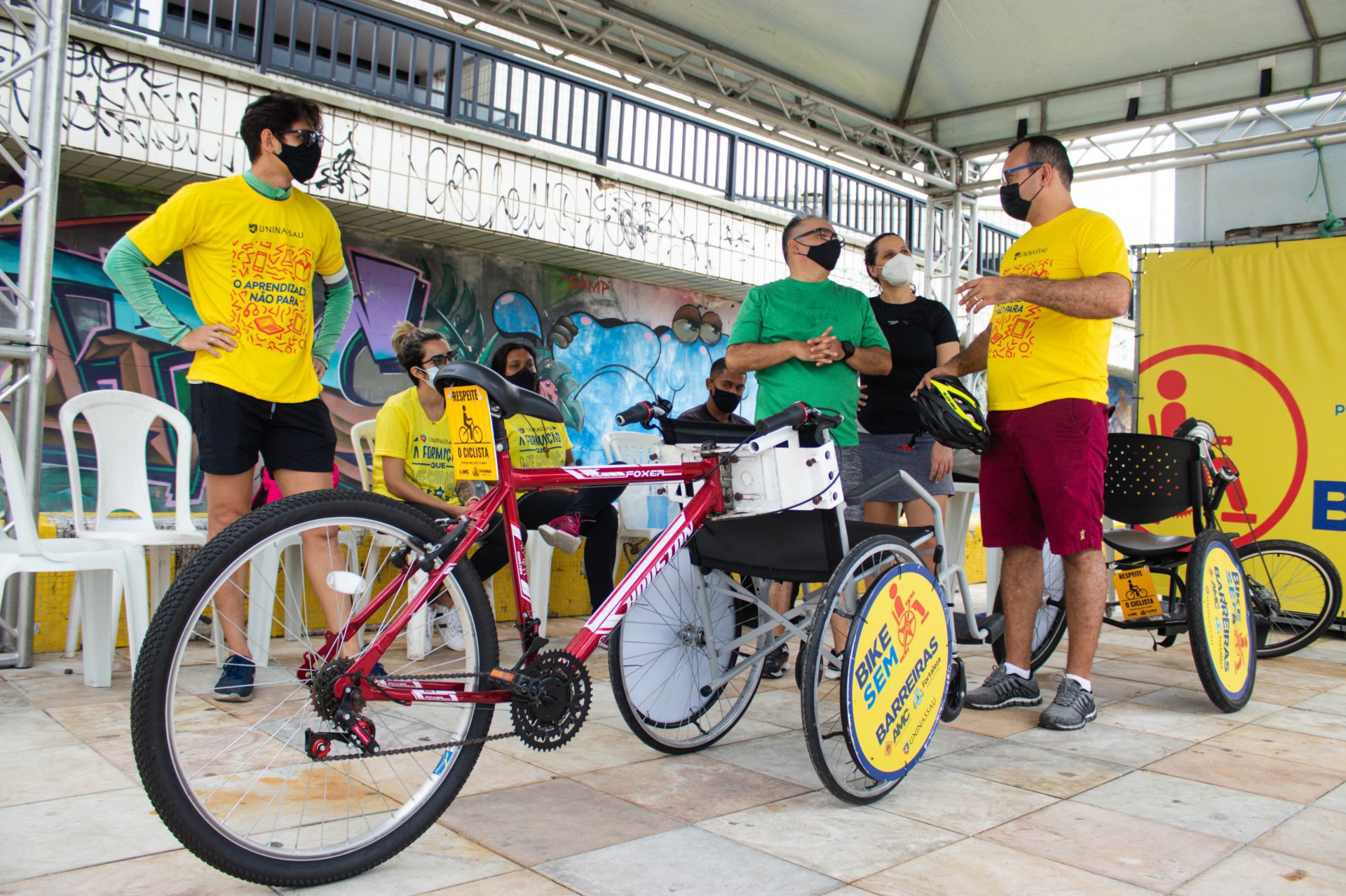 O coordenador Leonardo Freire explica para Francisco como a bicicleta The Duet funciona. O equipamento é disponibilizado para pessoas com mobilidade reduzida.
