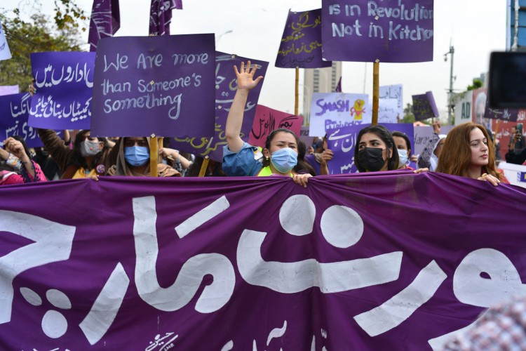 Manifestantes de Aurat March seguram cartazes e gritam slogans enquanto se reúnem para marcar o Dia Internacional da Mulher em Islamabad em 8 de março de 2022. 