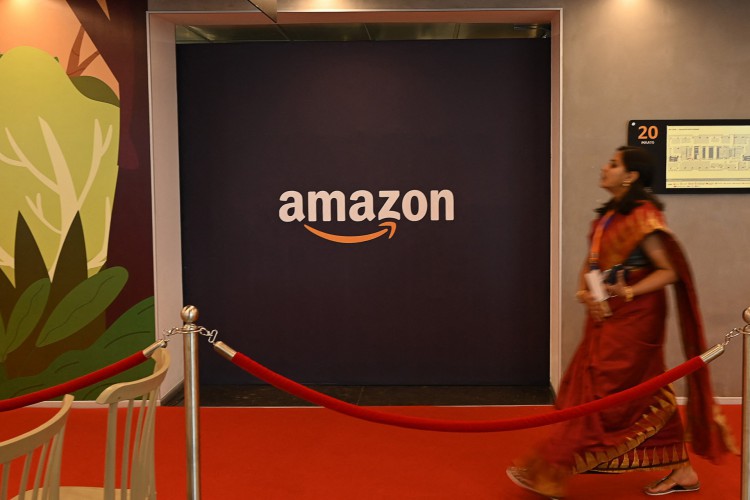 Um trabalhador passa por um logotipo da Amazon durante a inauguração do segundo maior espaço de escritório da Amazon em Chennai em 29 de março.