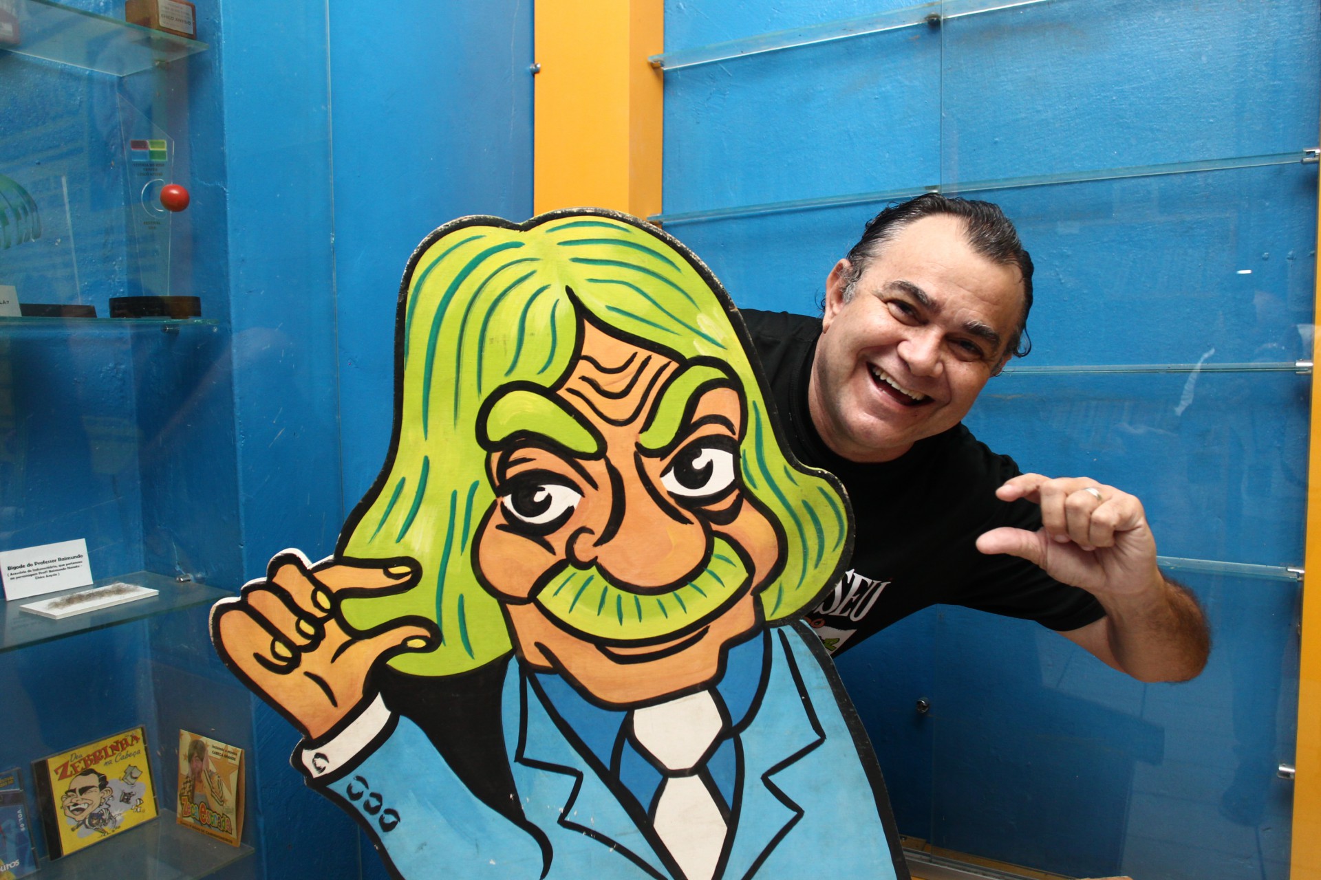 Jader Soares, humorista e historiador conhecido pelo personagem "Zebrinha", em visita guiada do Vida&Arte ao Museu do Humor Cearense, ao lado de totem do Professor Raimundo, personagem de Chico Anysio, cearense de Maranguape (Foto: FABIO LIMA)