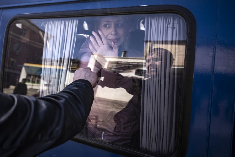 Uma mulher acena para se despedir do marido ao sair de ônibus, um dia após um ataque com foguete em uma estação de trem em Kramatorsk, em 9 de abril de 2022. Pelo menos 52 pessoas morreram, incluindo cinco crianças, após um foguete ataque em 8 de abril em uma estação de trem na cidade de Kramatorsk, no leste da Ucrânia, que está sendo usada para evacuações de civis, de acordo com o governador da região de Donetsk