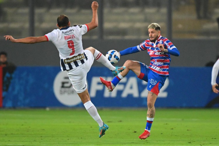 Atacante Hernán Barcos e ala Lucas Crispim disputam bola no jogo Alianza Lima x Fortaleza, no estádio Nacional, pela Copa Libertadores