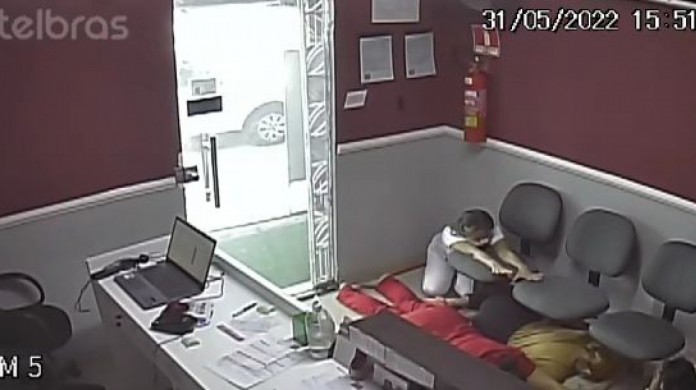 Vítimas deitadas no chão enquanto assaltantes realização ação criminosa na clínica 