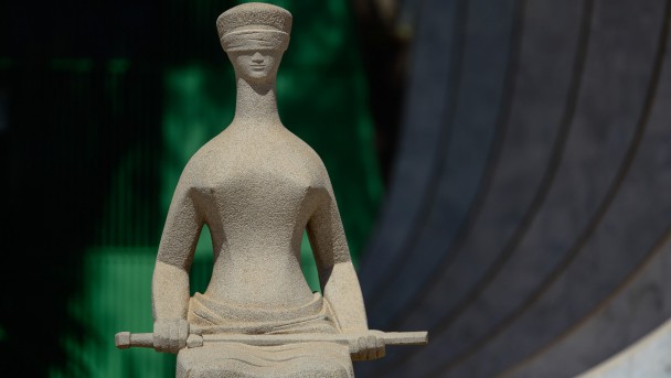 A estátua da deusa da Justiça, Thêmis, com os olhos enfaixados e a espada em mãos, na fachada da maior instância do Judiciário, o Supremo Tribunal Federal. Saiba mais sobre política no Brasil