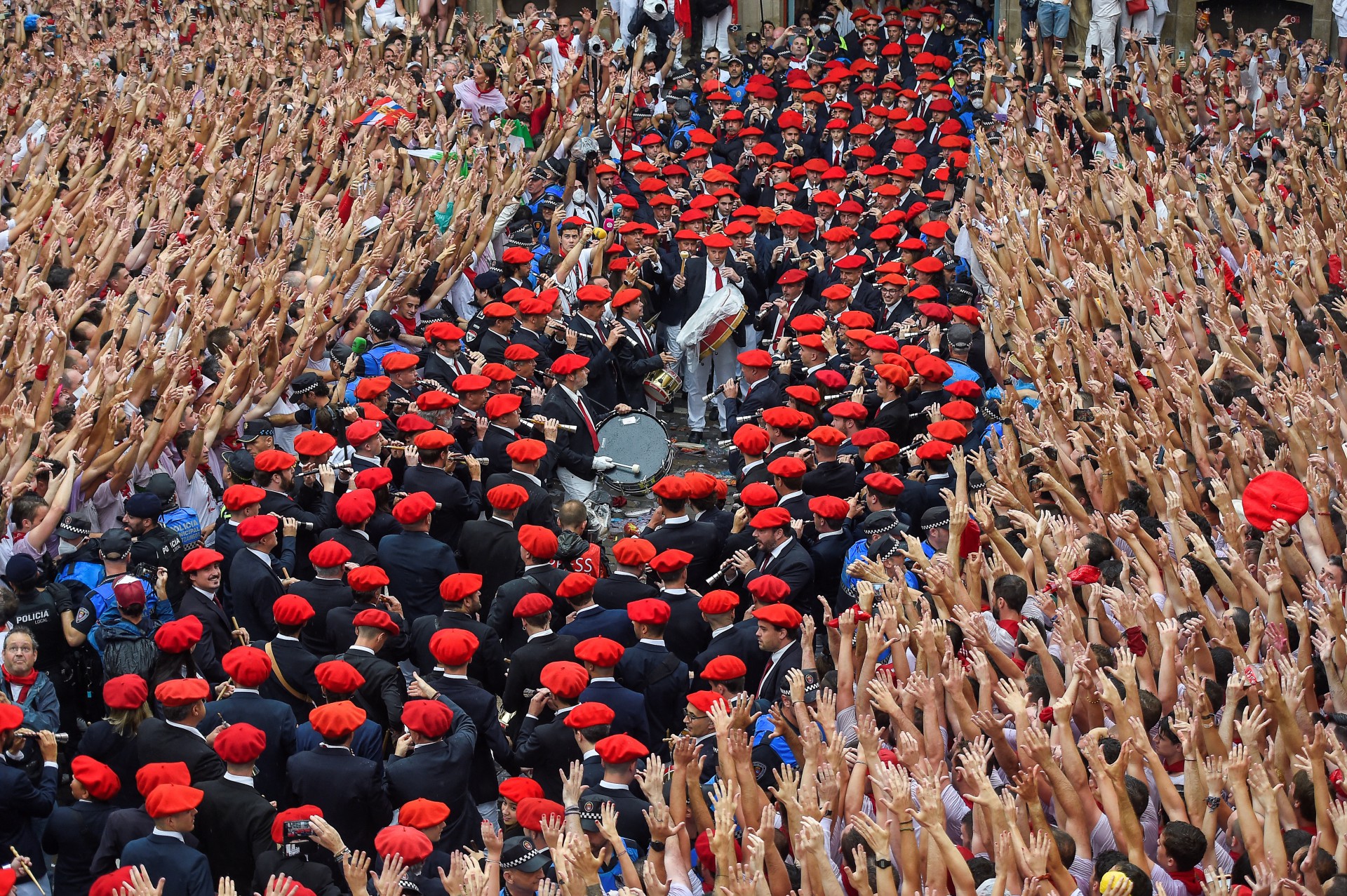 Os participantes comemoram enquanto a banda municipal de m&uacute;sica "Pamplonesa" se apresenta durante a cerim&ocirc;nia de abertura "Chupinazo" (foguete de partida) para marcar o in&iacute;cio do Festival de San Fermin fora da Prefeitura de Pamplona, ​​no norte da Espanha, em 6 de julho de 2022