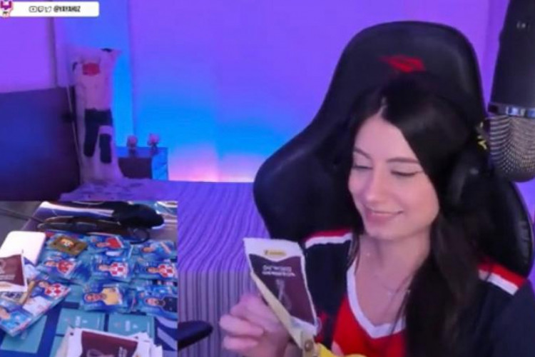 Streamer Yayah cortando um dos pacotes de figurinhas do álbum da Copa do Mundo