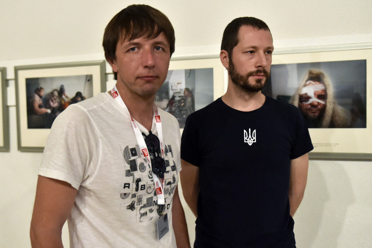 Nesta fotografia tirada em 31 de agosto de 2022, os fotógrafos ucranianos Evgeniy Maloletka (E) e Mstyslav Chernov (D) posam na frente de suas fotos na exposição 
