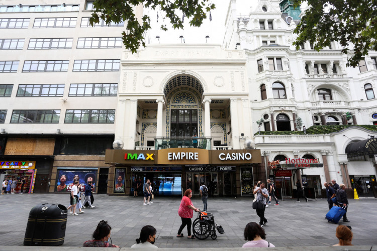 Nesta foto de arquivo tirada em 22 de agosto de 2022, pedestres passam pela entrada de um cinema Cineworld em Londres. A segunda maior cadeia de cinema do mundo, a Cineworld, anunciou em 7 de setembro de 2022 que entraria com pedido de falência nos Estados Unidos, a fim de reestruturar seu passivo e tentar encontrar nova liquidez em meio à crise em salas escuras