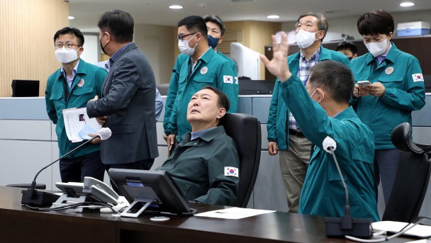 This handout from the South Korean Presidential Office taken and released on October 30, 2022 shows South Korea's President Yoon Suk-yeol (C) attending an emergency meeting, regarding the Halloween stampede, at the presidential office in Seoul. - More than 140 people were killed on October 29 and some 150 were injured in a horrific stampede in central Seoul when a large crowd celebrating Halloween crammed into a narrow street, officials said. (Photo by Handout / South Korean Presidential Office / AFP)