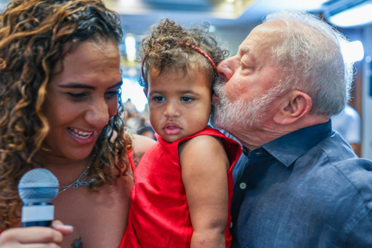 Anielle Franco segura a filha, que recebe beijo de Lula em ato de campanha no Rio de Janeiro