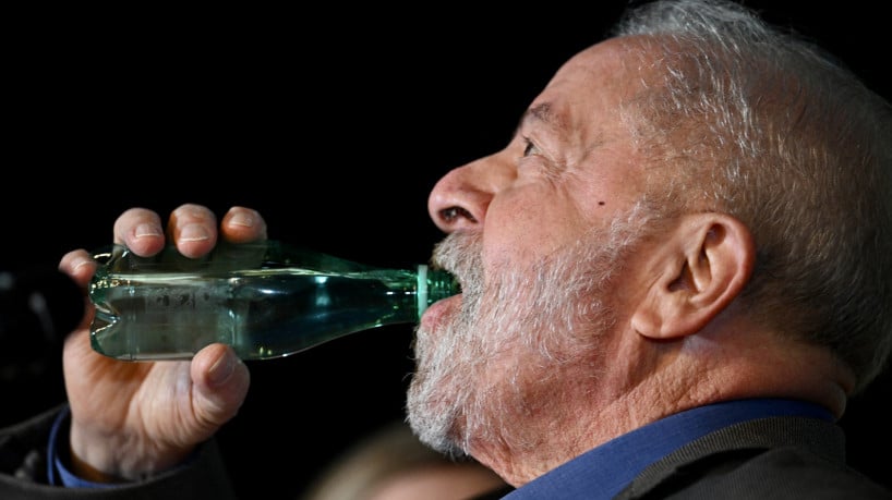 Lula toma garrafa de água durante anúncio de ministros(foto: Evaristo Sá / AFP)