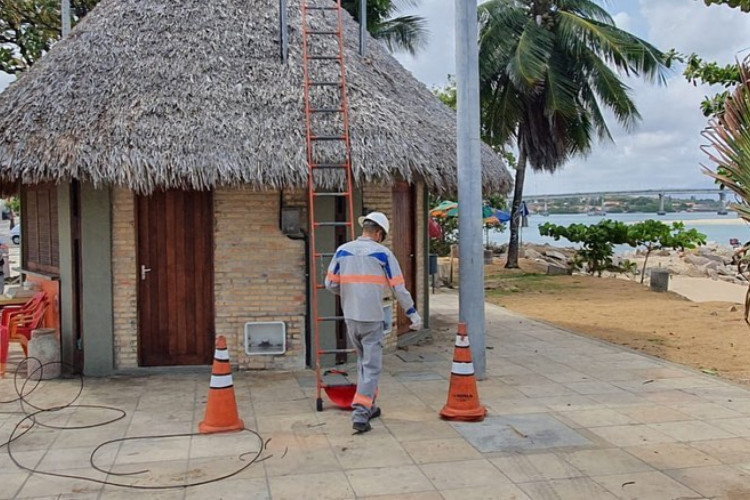 Funcionário da Enel realiza instalação de energia elétrica em quiosque da Barra do Ceará