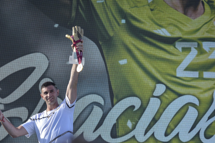 O goleiro da seleção argentina Emiliano Martinez segura medalha de ouro e troféu luva de ouro concedidos pela FIFA durante homenagem a ele, em Mar del Plata, Argentina, em 22 de dezembro de 2022, ao retornar à sua cidade natal após vencer o Catar 2022 torneio da Copa do Mundo 