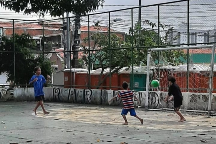 Crianças jogam futebol por trás de palco do bloco Luxo da Aldeia