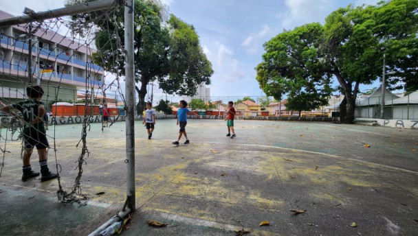 Crianças jogam futebol por trás de palco do bloco Mambembe


