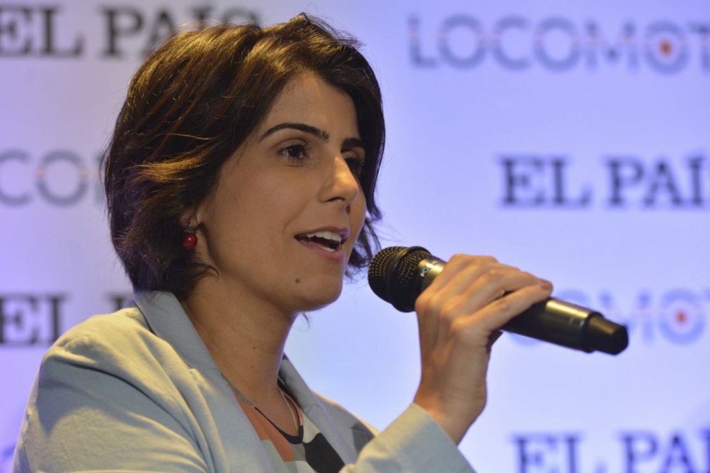 ParaTodosVerem: Manuela d'Ávila, ex-deputada federal. É uma mulher branca, de cabelos curtos. Usa um blazer cinza e fala ao microfone(Foto: Rovena Rosa/Agência Brasil)