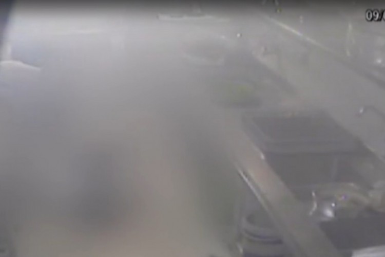 Mulher cai no chão após impacto da explosão, que deixa o ambiente recoberto de fumaça