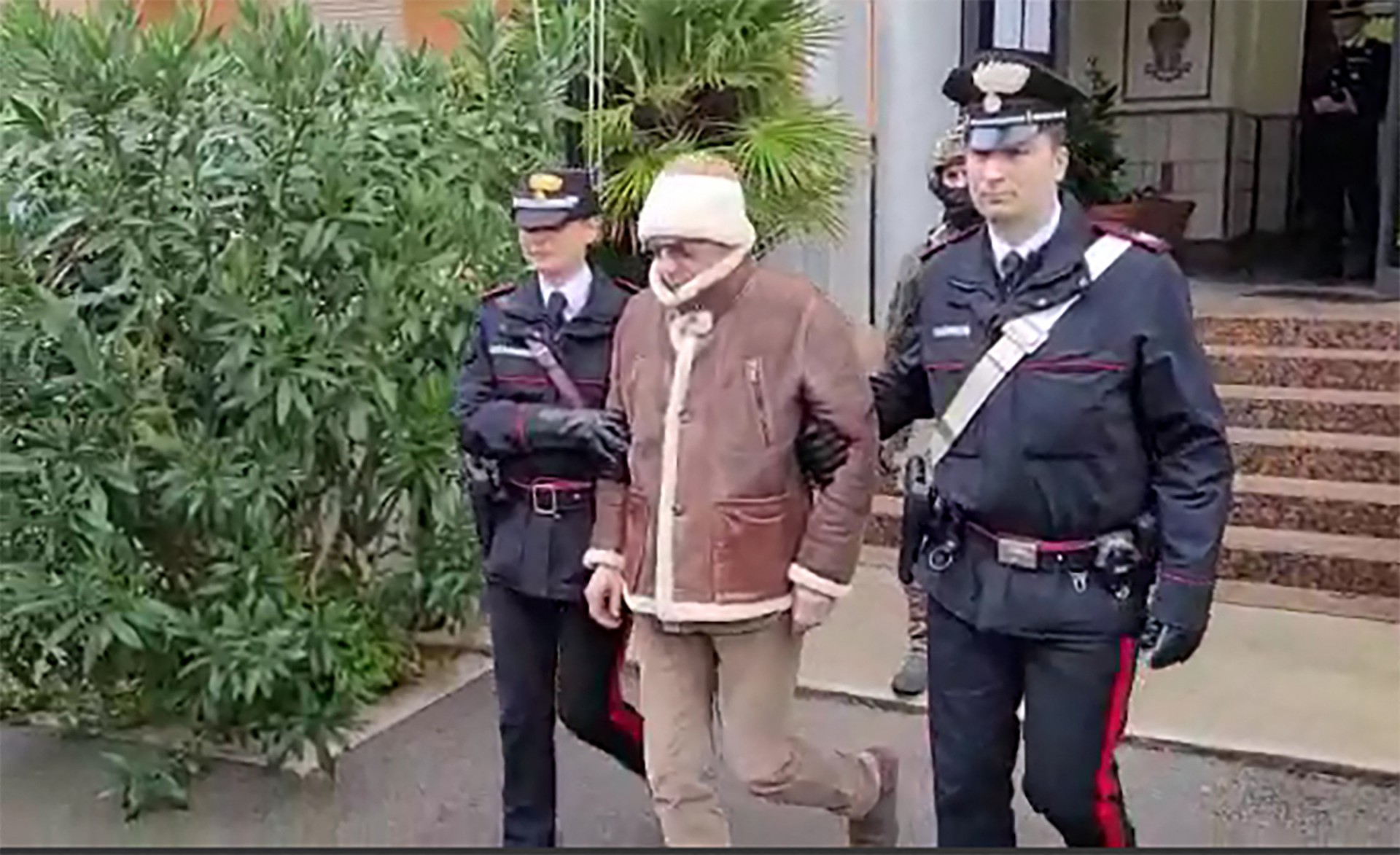 Esta reprodu&ccedil;&atilde;o de v&iacute;deo obtida e divulgado pela Assessoria de Imprensa dos Carabinieri italianos em 16 de janeiro de 2023 mostra a transfer&ecirc;ncia do chefe da m&aacute;fia mais procurado da It&aacute;lia, Matteo Messina Denaro (C) da delegacia Carabinieri de San Lorenzo em Palermo, para um localiza&ccedil;&atilde;o n&atilde;o revelada, ap&oacute;s sua pris&atilde;o em sua terra natal, a Sic&iacute;lia, ap&oacute;s 30 anos em fuga