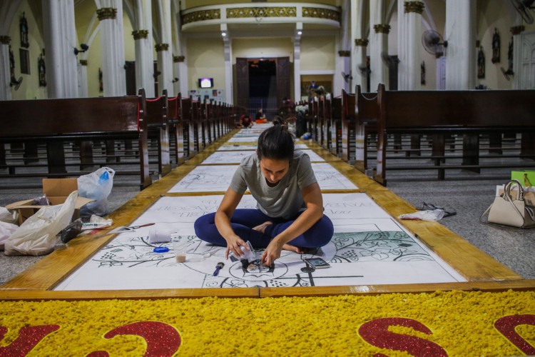 MEMBROS da igreja do Cristo Rei confeccionam os tapetes para Corpus Christi 
