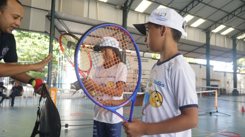 Criança do projeto Tênis Cidadão recebe raquete para prática do tênis