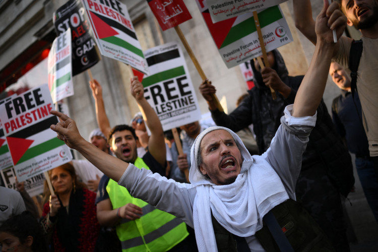 Pessoas participam numa manifestação 'Fique com a Palestina', perto da Embaixada de Israel, no oeste de Londres, em 9 de outubro de 2023
