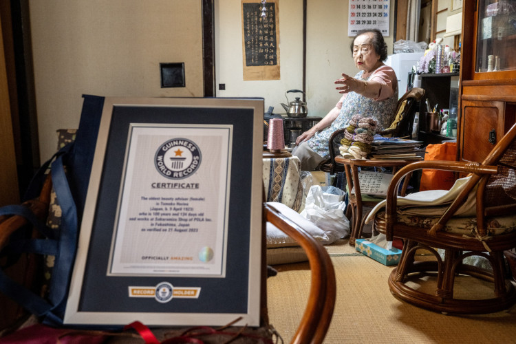 Tomoko Horino em sua casa, tendo &agrave; frente o certificado do Guinness Book como mais velha consultora de beleza do mundo