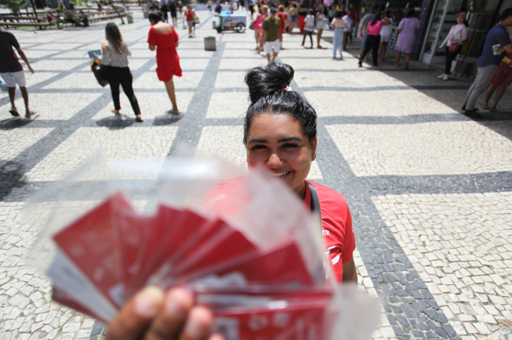 Enfrentando o Sol, Nadynne Andrade é vendedora de chips de telefonia na Praça do Ferreira, em Fortaleza(Foto: FÁBIO LIMA)