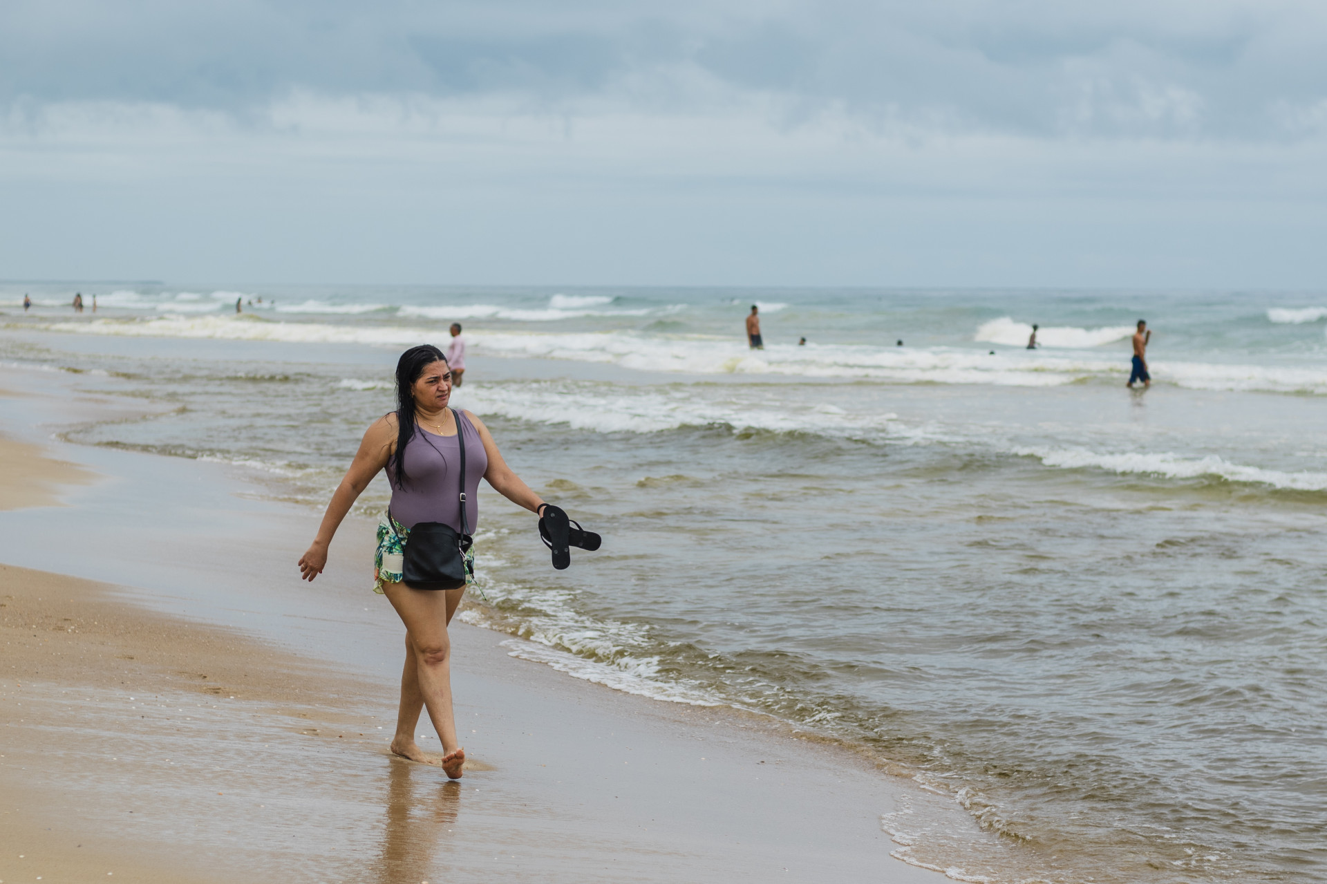 Na foto, banhistas visitam a Praia do Futuro e dão um mergulho, mesmo com o mar apresentando outra tonalidade