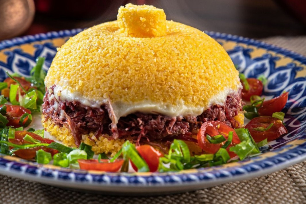 Cuscuz Pacajus: cuscuz recheado com carne seca e catupiry, finalizado com tomatinho, cebolinha e pimenta biquinho.