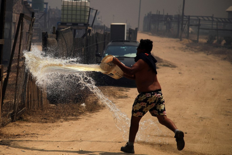 Um homem apaga um incêndio florestal na zona de um incêndio florestal nas colinas da comuna de Quilpe, região de Valparaíso, Chile, em 3 de fevereiro de 2024. A região de Valparaiso e Viña del Mar, no centro do Chile, acordou no sábado com um toque de recolher parcial para permitir a movimentação de evacuados e a transferência de equipamentos de emergência em meio a uma série de incêndios sem precedentes, informaram as autoridades