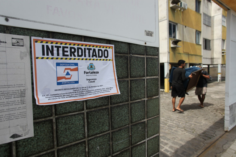 Homens retiram móveis do Residencial Santa Helena, na Cidade dos Funcionários, em Fortaleza. Prédio foi interditado pela Defesa Civil do Município