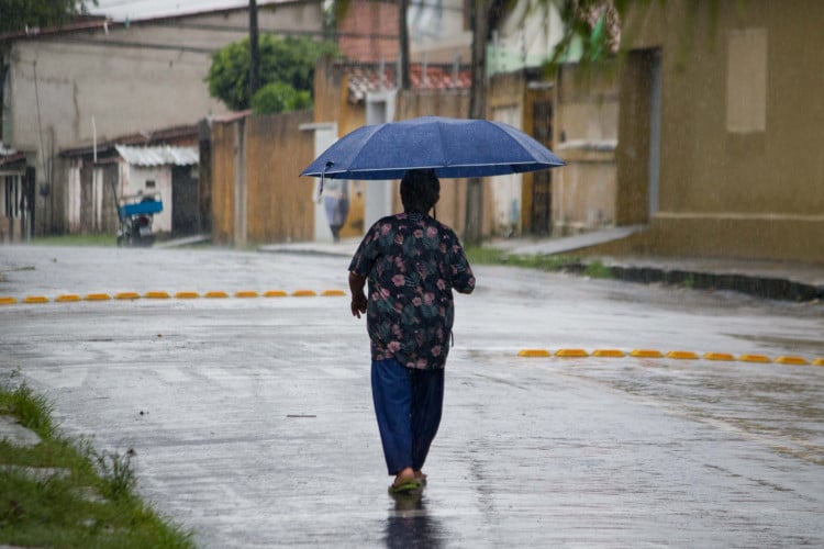 FORTALEZA, CEARÁ, BRASIL, 15-03-2024: Chuva pela manhã na Av. Godofredo Maciel, movimentação de pessoas com guarda-chuva e capas de chuva. (Foto: Samuel Setubal)