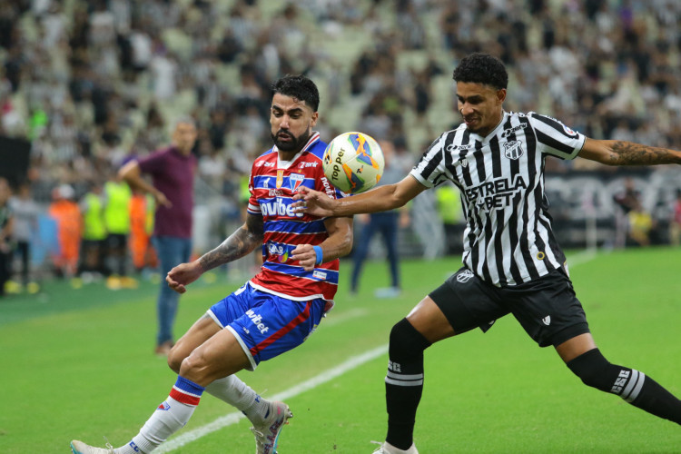 O zagueiro Brítez, do Fortaleza, e o lateral Paulo Victor, do Ceará, em disputa de bola no Clássico-Rei. Ceará e Fortaleza se enfrentam pela final do Campeonato Cearense; veja onde assistir aos jogos deste sábado, 06 de abril. 