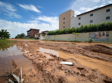 Via tem acúmulo de água, lama e morros de areia desnivelados no bairro Porto das Dunas 