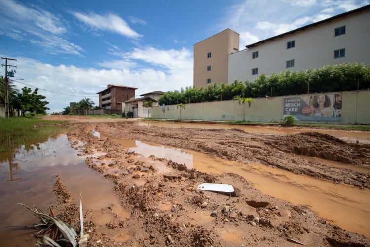 Via tem acúmulo de água, lama e morros de areia desnivelados no bairro Porto das Dunas