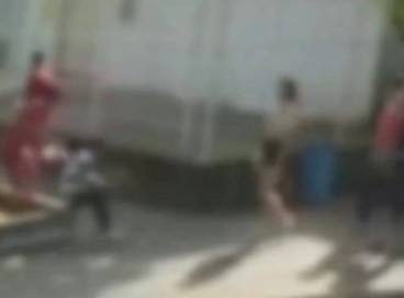 À esquerda, o suspeito, vestindo camisa vermelha, aparece jogando líquido inflamável na vítima, de camisa listrada, que está sentada 