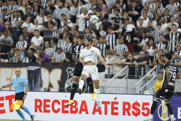 Jogadores de Ceará e Goiás dividem bola no alto durante abertura da Série B 2024, na Arena Castelão.