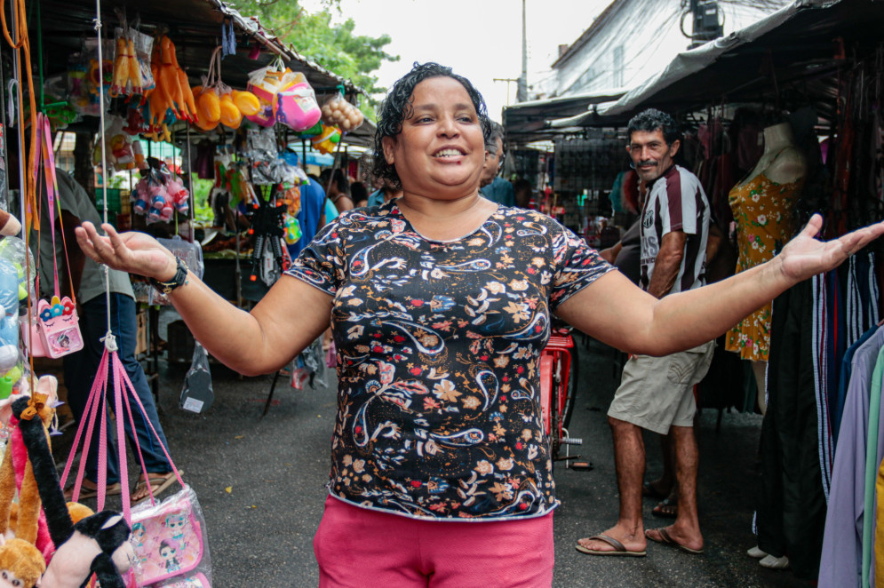 Vendedora da Feira das Goiabeiras dá boas vindas aos clientes num domingo de chuva na Barra do Ceará, em abril de 2024(Foto: Yuri Allen/Especial para O Povo)