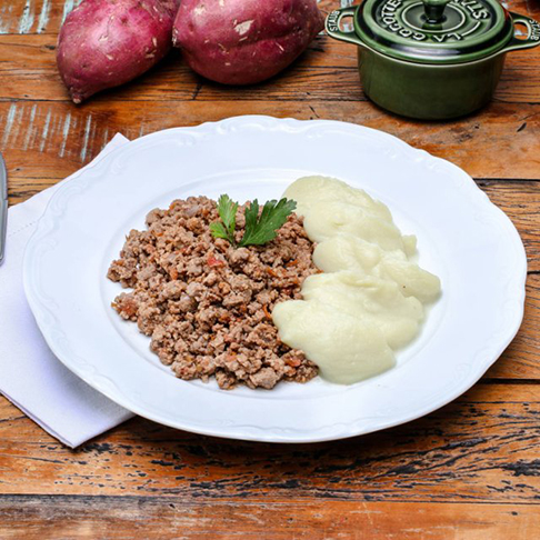  A melhor carne para moer é o acém. Fica mais suculenta (por causa dos lipídeos) do que uma carne mais nobre, como o filé. A proteína animal combina bem com o purê de batata, que pode ficar mais ou menos gorduroso conforme a quantidade de manteiga na mistura. A batata é rica em niacina e potássio. E dá energia.  