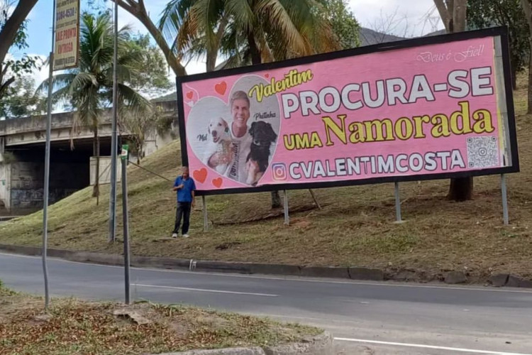 Carlos Valentim usou outdoors para anunciar sua procura por uma namorada antes do dia dos namorados. No anúncio ao ar livre, exibe fotos com seus dois cães e um código para seu perfil nas redes sociais
