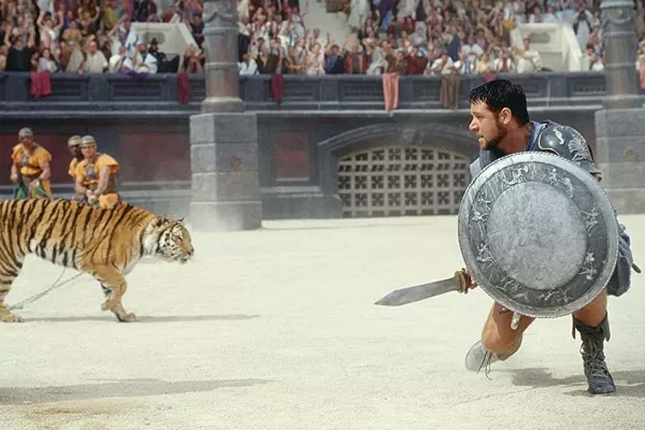 No primeiro filme, Lucius Verus, sobrinho de Commodus (Joaquim Phoenix), teve a vida salva pelo general romano Maximus. 
