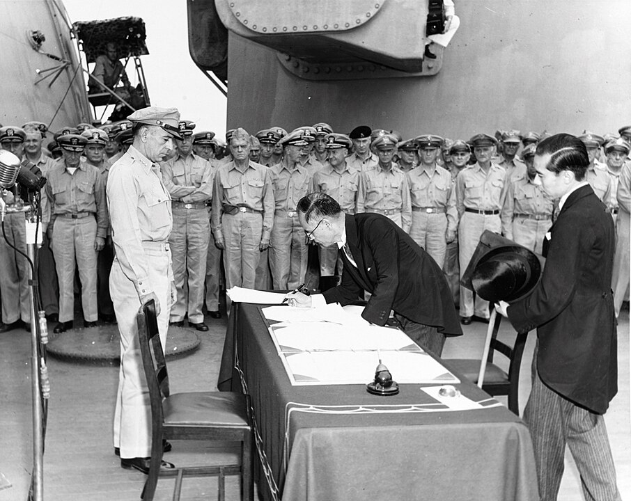 No dia 02/09/45, o Ministro das Relações Exteriores do Japão Mamoru Shigemitsu assinou a Ata de rendição do país no USS Missouri sendo visto por Richard K. Sutherland, oficial do Exército dos EUA.