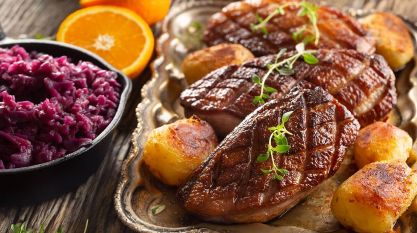Peito de pato grelhado com batatas assadas e repolho roxo (Imagem: Marian Weyo | Shutterstock)