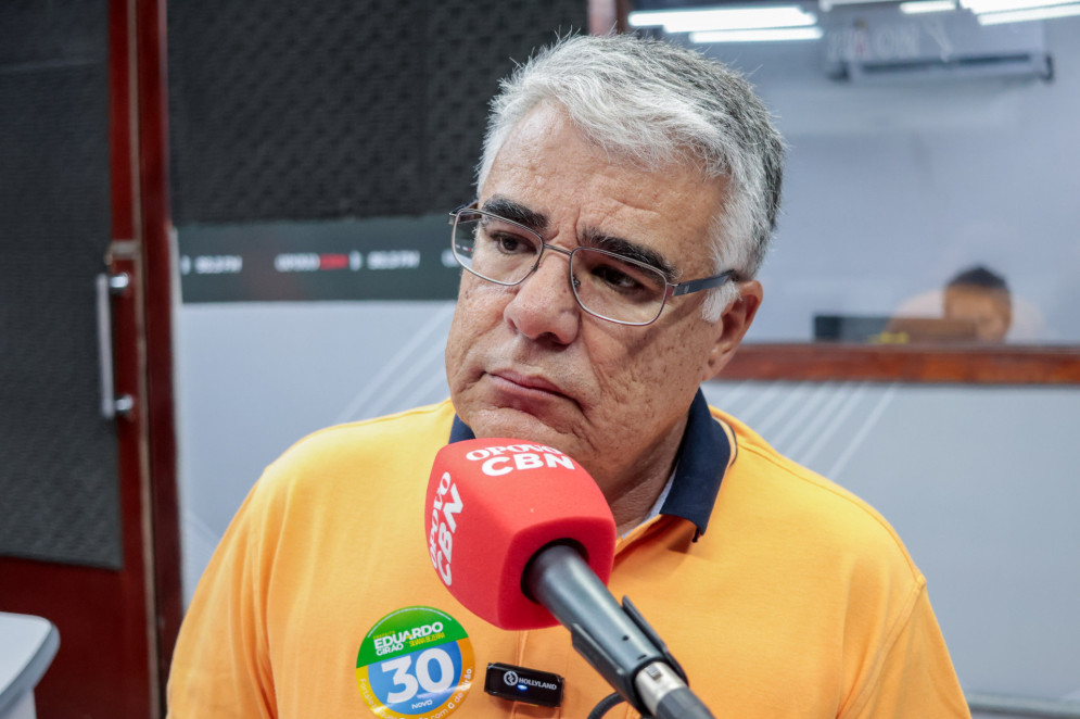 Eduardo Gir&atilde;o &eacute; um homem branco, de cabelos grisalhos e &oacute;culos com arma&ccedil;&atilde;o quadrada