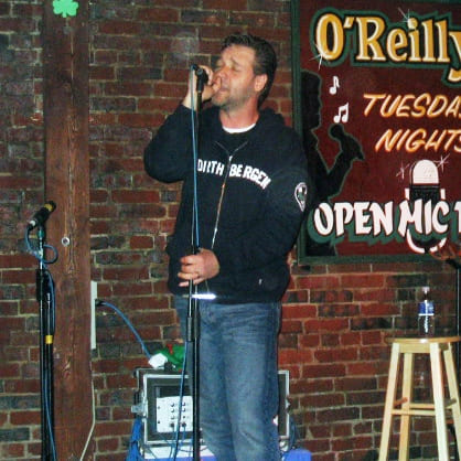 Desde os anos 1980 Russell Crowe, além de atuar, também se apresenta cantando e tocando.  Na foto, o ator neozelandês faz uma apresentação no  O'Reilly's Pub , em St. John's, no Canadá, em junho de 2005. 